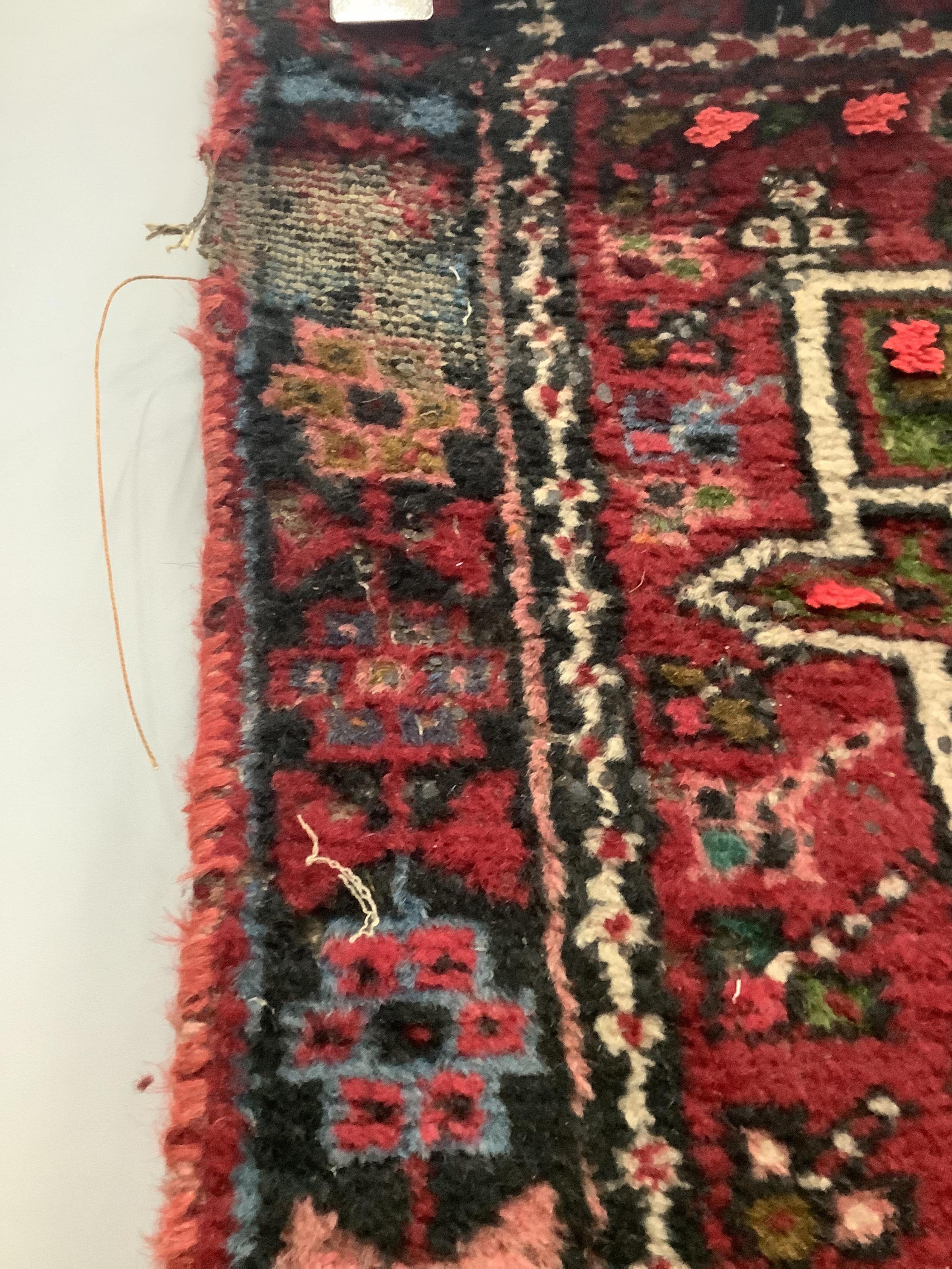 A Persian dark red ground runner, 386 x 88cm. Condition - poor, worn at both ends